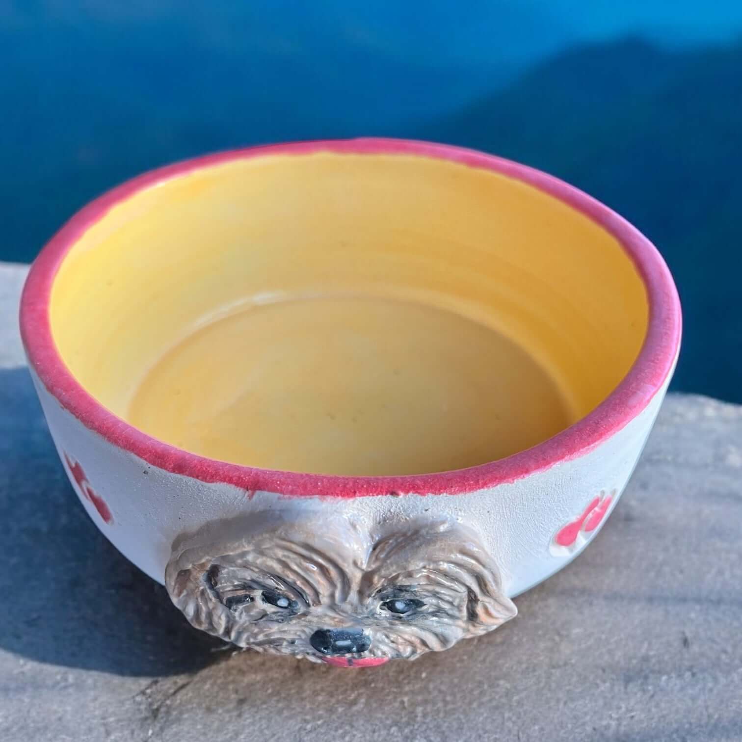 Hand-painted dog bowl featuring a Cockapoo face and a yellow interior, perfect for food or water.