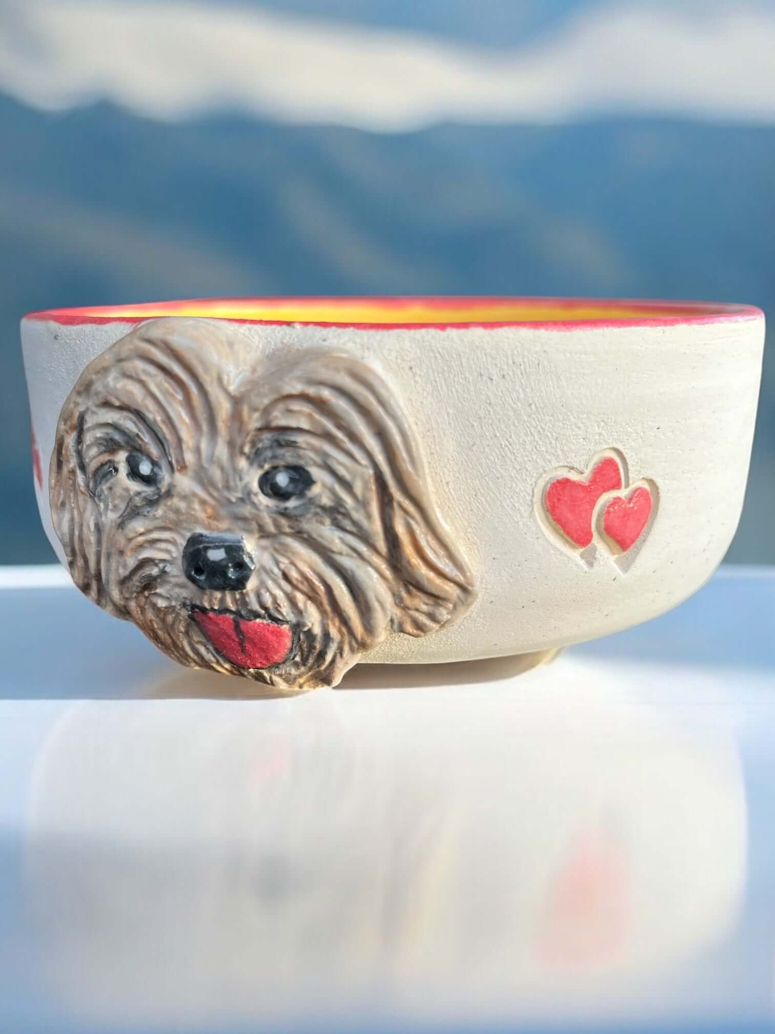 Hand-painted dog bowl featuring a Cockapoo face and red hearts, perfect for food or water.