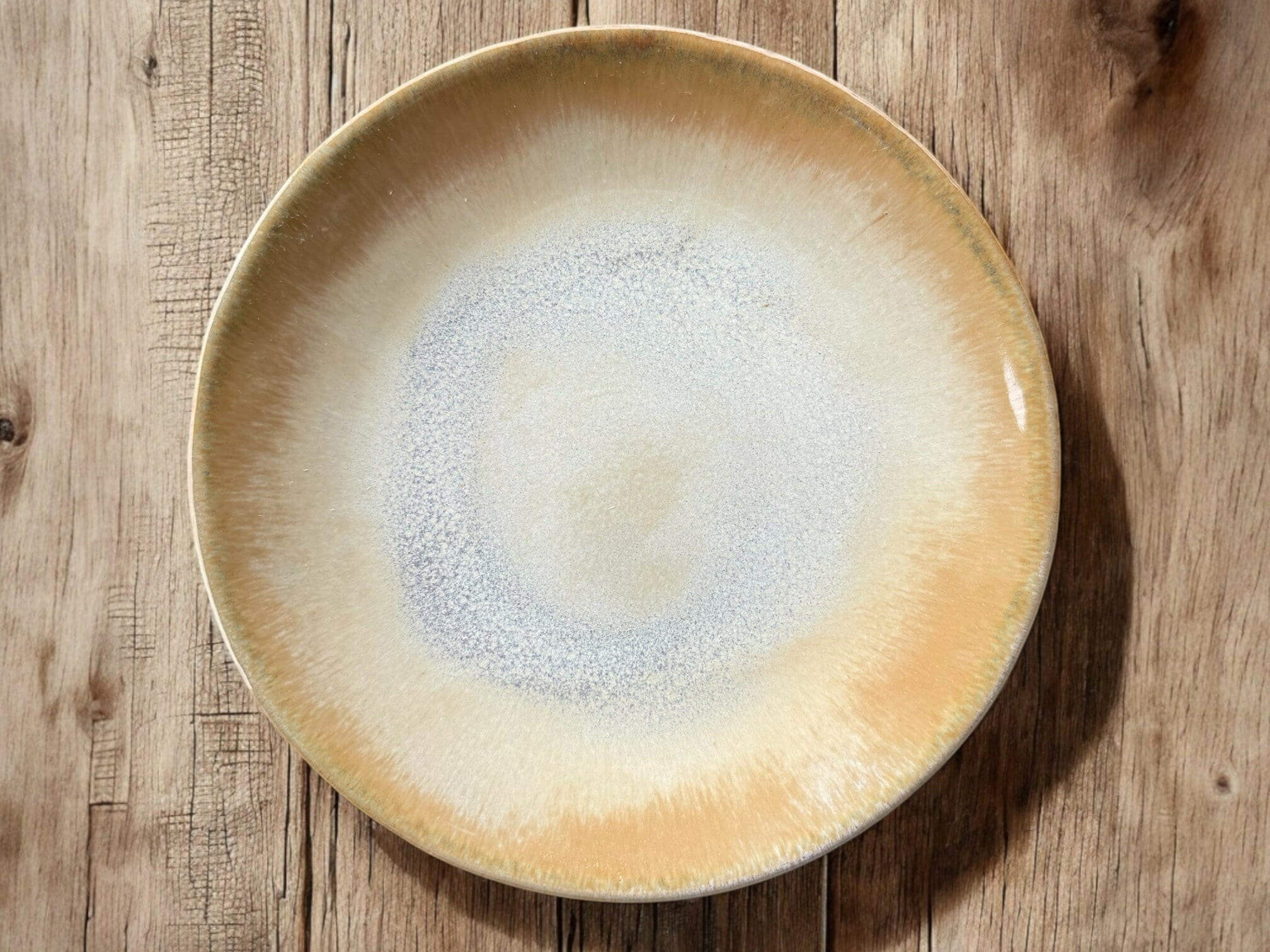 Handmade ceramic plate with creamy beige and grey-blue tones, 16 cm diameter, perfect for serving small bites.