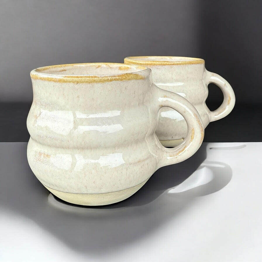 Handmade ribbed speckled stoneware mugs with earthy finish, perfect for coffee or tea.