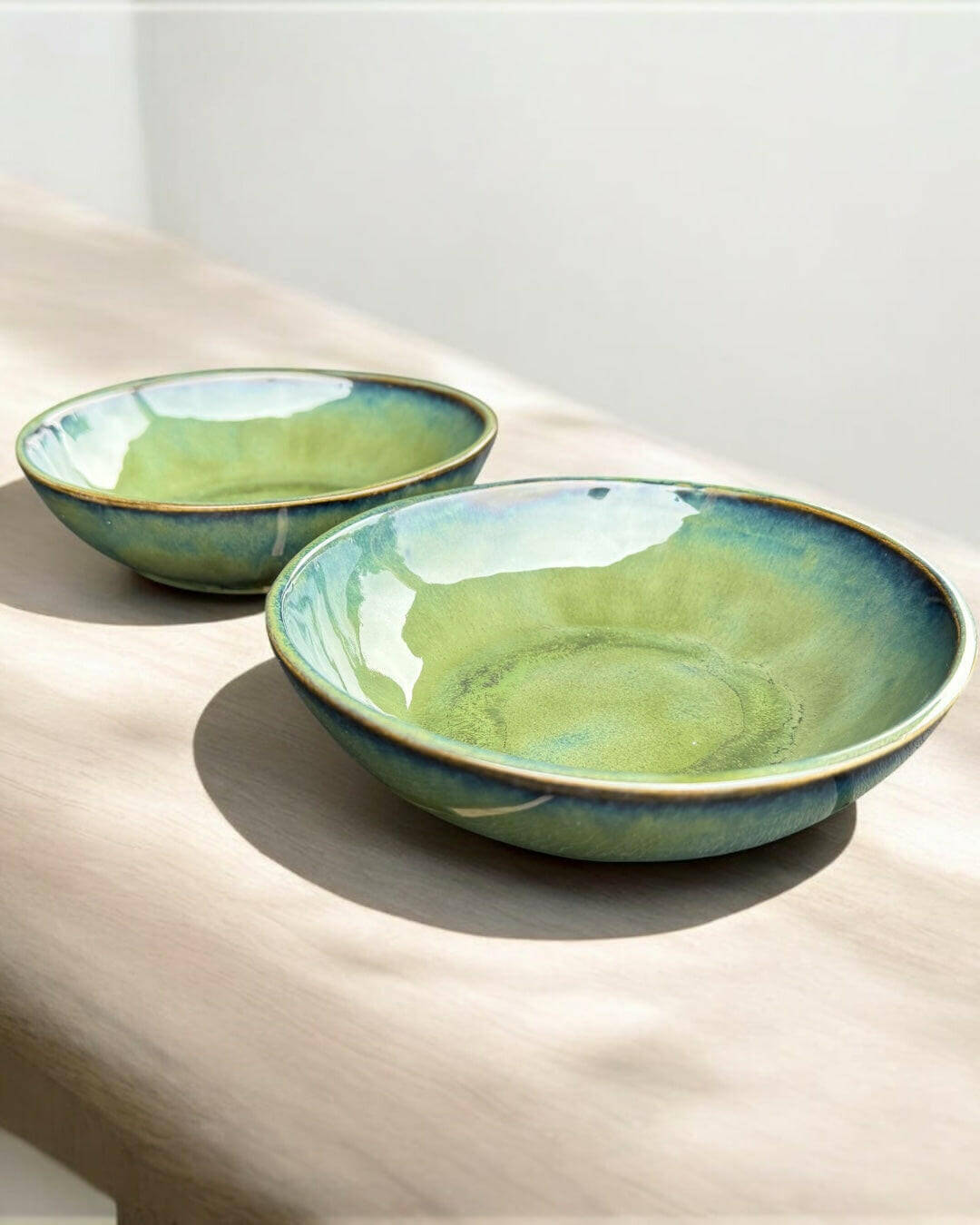 Handmade bowls in flowing green and blue hues, perfect for salads or as decorative pieces.