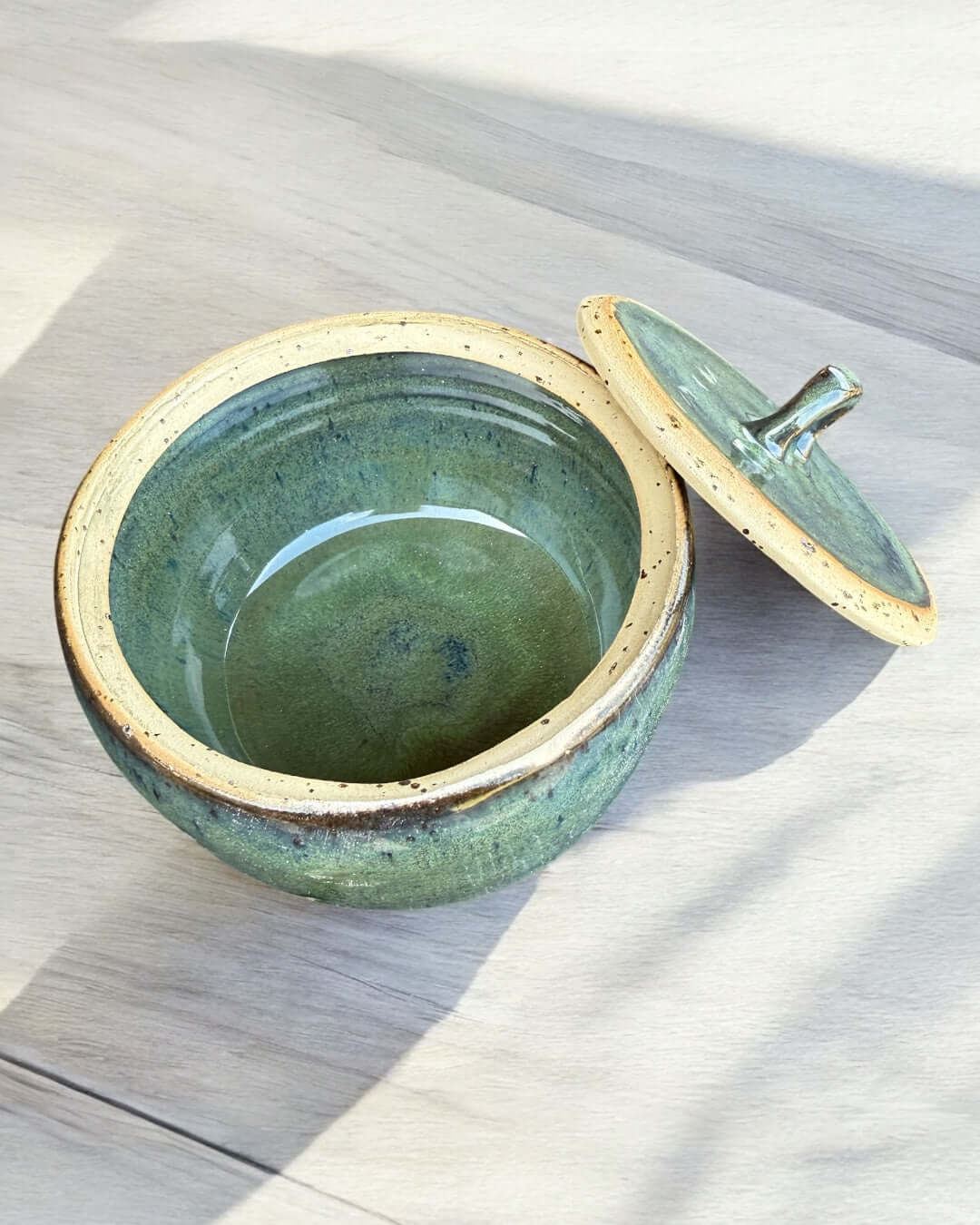Handmade green ceramic jar with lid, glossy seaweed tones, decorative stoneware container, 10.5 cm diameter.