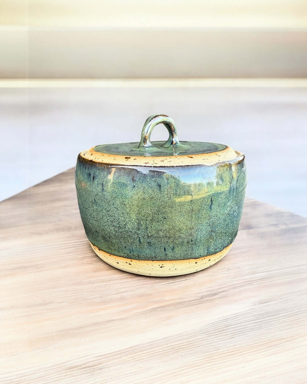Handmade green ceramic jar with lid, glossy seaweed tones, 10.5 cm diameter, ideal for storage or decor.