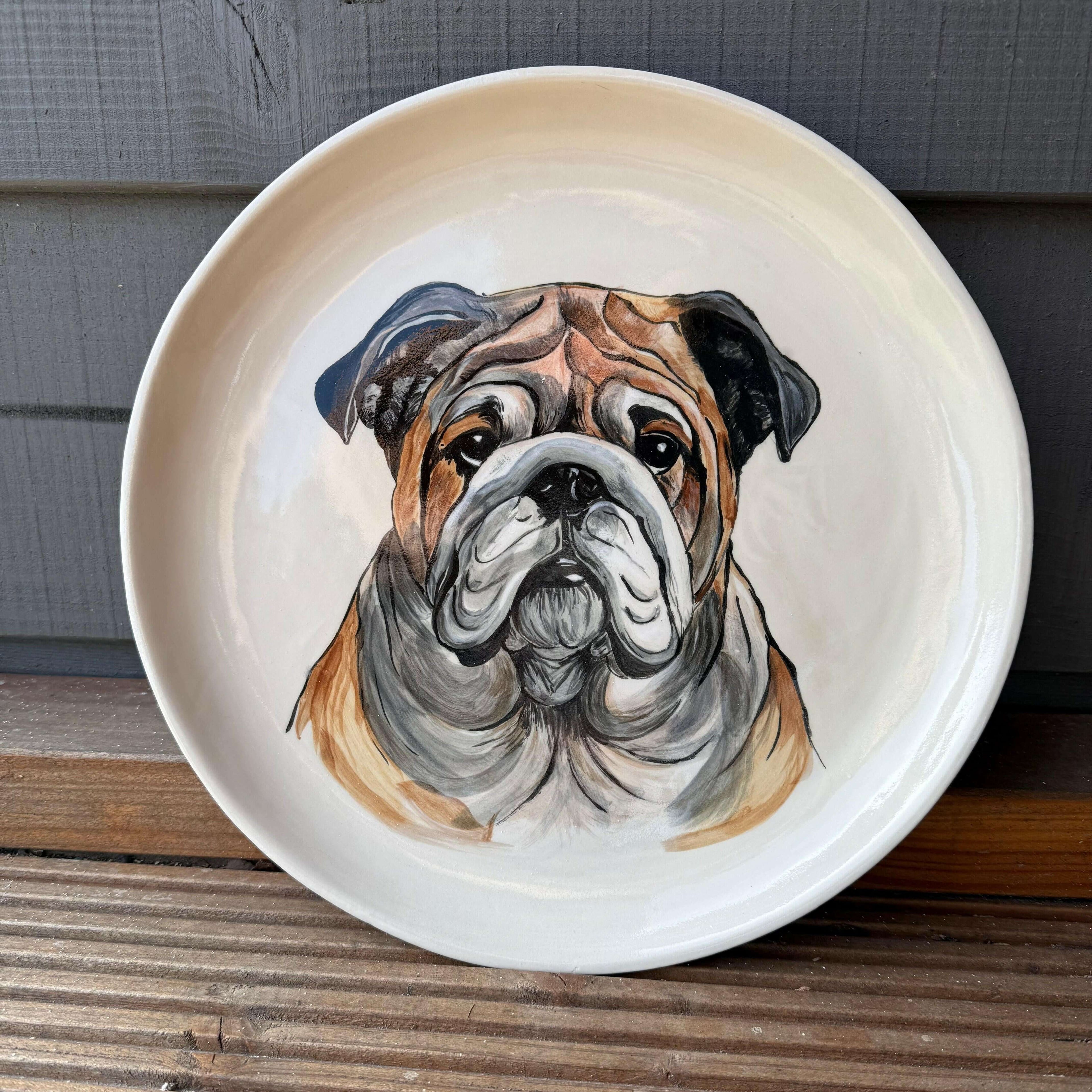 Hand-painted decorative plate featuring a detailed portrayal of a bulldog face.