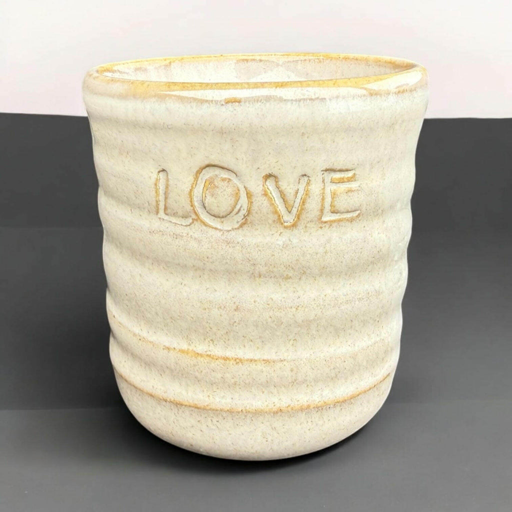 Handmade mug featuring a textured design with the word 'LOVE' embossed on the front. Ideal for gifting.