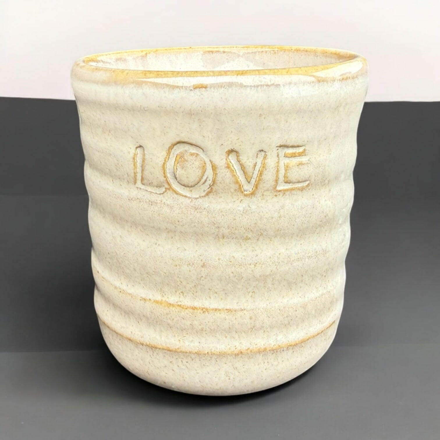 Handmade mug featuring a textured design with the word 'LOVE' embossed on the front. Ideal for gifting.