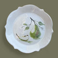Hand-painted pear ceramic plate with scalloped edge, featuring a pear illustration on a white background.