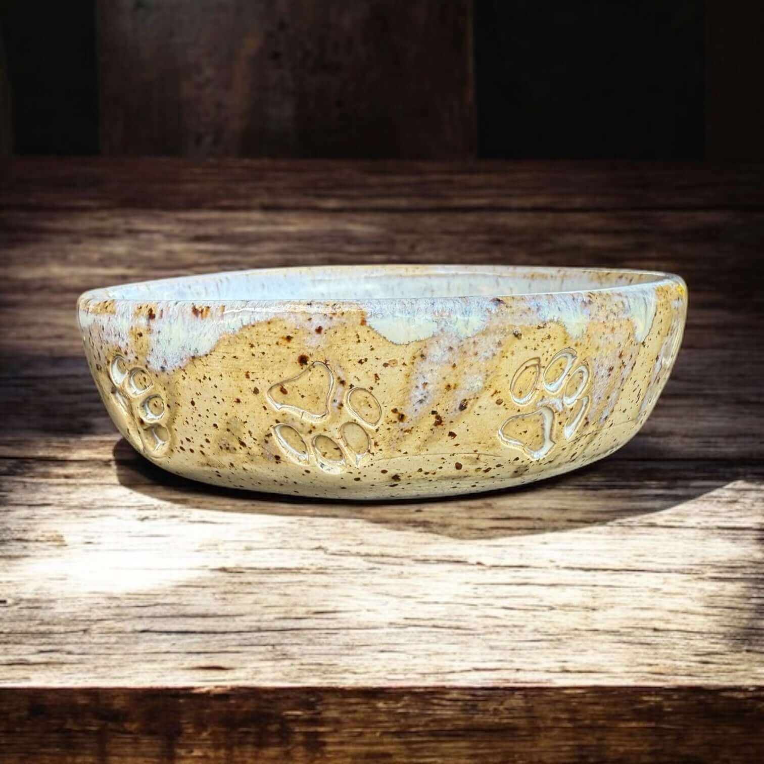Handgemaakte hondenkom van steengoed met pootafdrukken, perfect voor hondenmaaltijden of water.