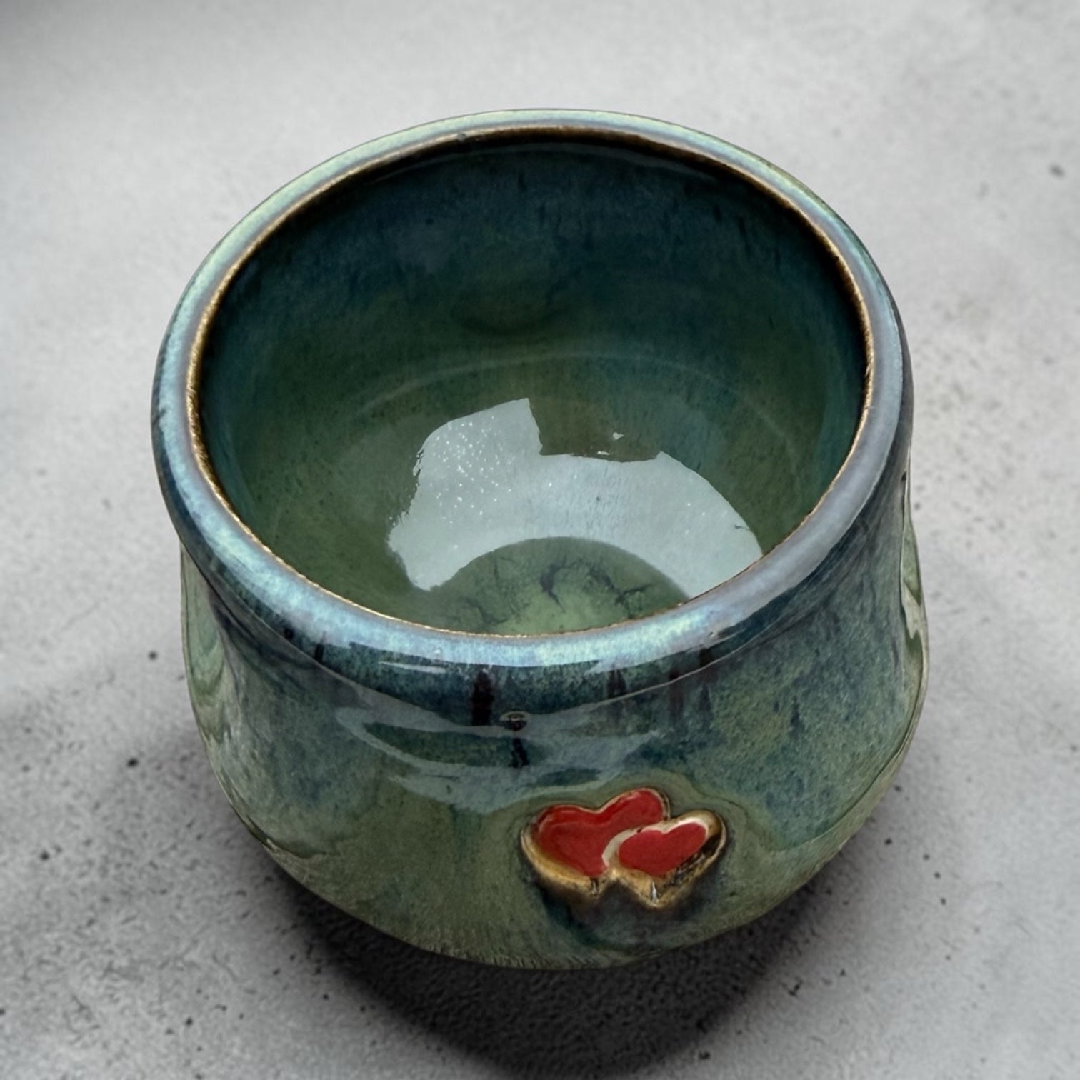 Handmade ceramic cup – green glaze with heart detail